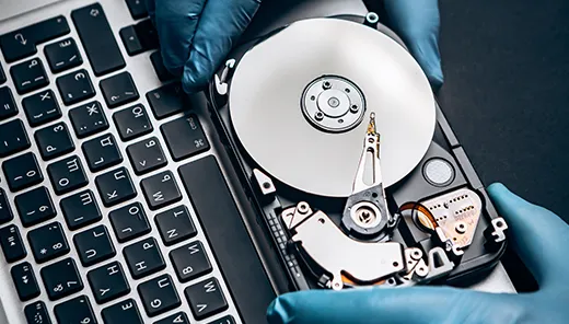 Person in blue gloves holding a hard drive